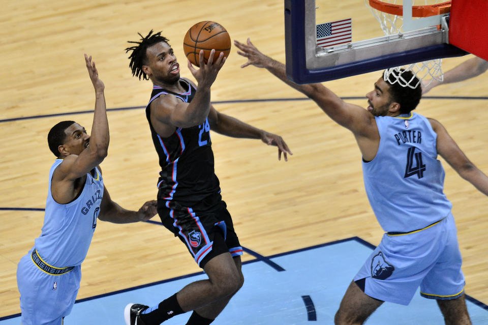 Sacramento Kings guard Buddy Hield (24) shoots between Memphis Grizzlies forward Jontay Porter (4) and guard De'Anthony Melton (0) in the second half of an NBA basketball game Friday, May 14, 2021, in Memphis, Tenn. (AP Photo/Brandon Dill)