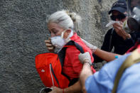 Demonstrators react affected by tear gas while rallying against Venezuela's President Nicolas Maduro in Caracas, Venezuela May 1, 2017. REUTERS/Carlos Garcia Rawlins