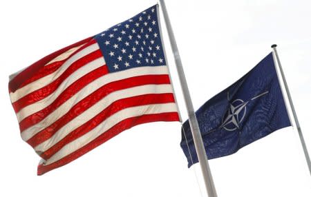 FILE PHOTO: NATO and U.S. flags fly at the entrance of the Alliance's headquarters during a NATO foreign ministers meeting in Brussels, Belgium March 31, 2017. REUTERS/Yves Herman/File Photo