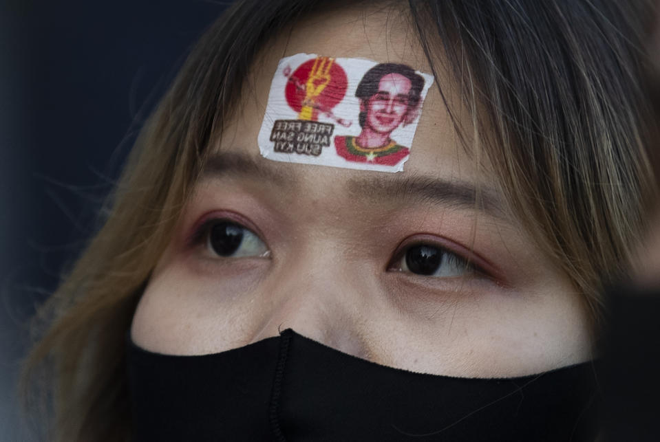 A supporter of a protest group called "WeLoveMyanmar" wears a sticker with an image of Myanmar leader Aung San Suu Kyi as they gather for a protest against the Myanmar military in front of the United Nations University in Tokyo on Thursday, Feb. 11, 2021. (AP Photo/Hiro Komae)