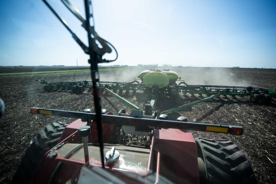 A tractor pulls a planter filled with seed as the Heineman family plants corn Wednesday near Ogden in Boone County.