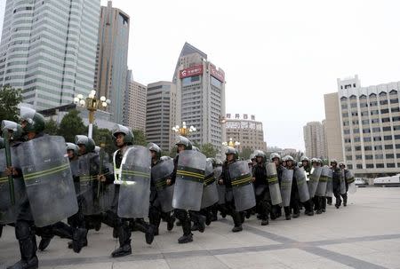 Armed paramilitary policemen run in formation during a gathering to mobilize security operations in Urumqi, Xinjiang Uighur Autonomous Region, in this June 29, 2013 file photo. REUTERS/Stringer/Files