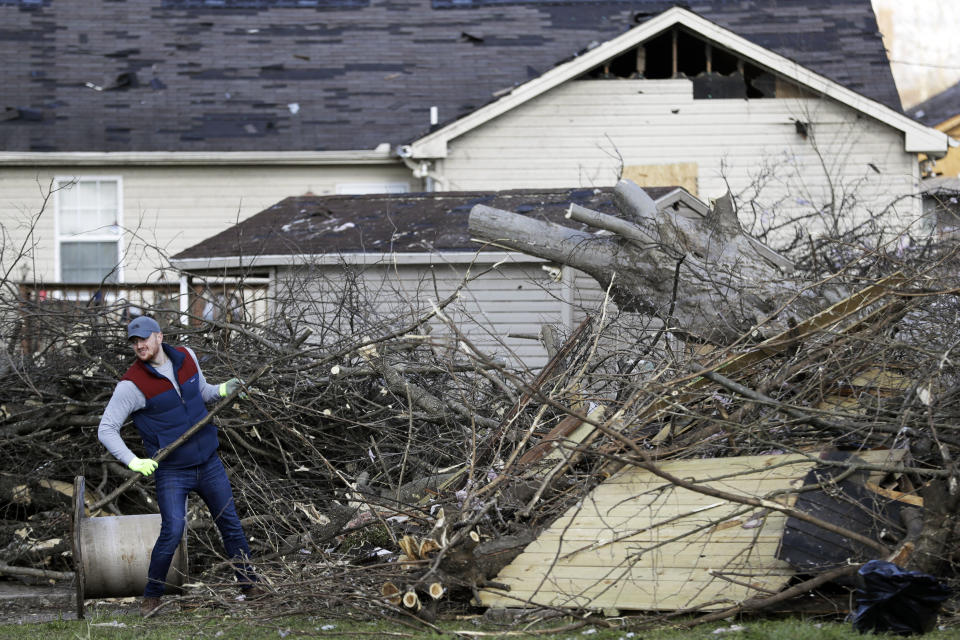 Jim Savelyev cleans up debris in a residential area Friday, March 6, 2020, in Nashville, Tenn. Residents and businesses face a huge cleanup effort after tornadoes hit the state Tuesday. (AP Photo/Mark Humphrey)
