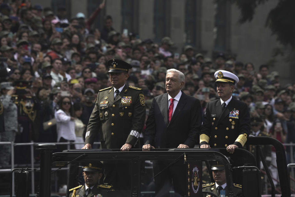 Cmd. Luis Cresencio Sandoval, from left, Mexico's President Andrés Manuel López Obrador and Adm. Rafael Ojeda Durán, Secretary of the Navy, review the troops before the start of the annual Independence Day parade in the capital's main square, the Zocalo, in Mexico City, Saturday, Sept. 16, 2023. (AP Photo/Fernando Llano)