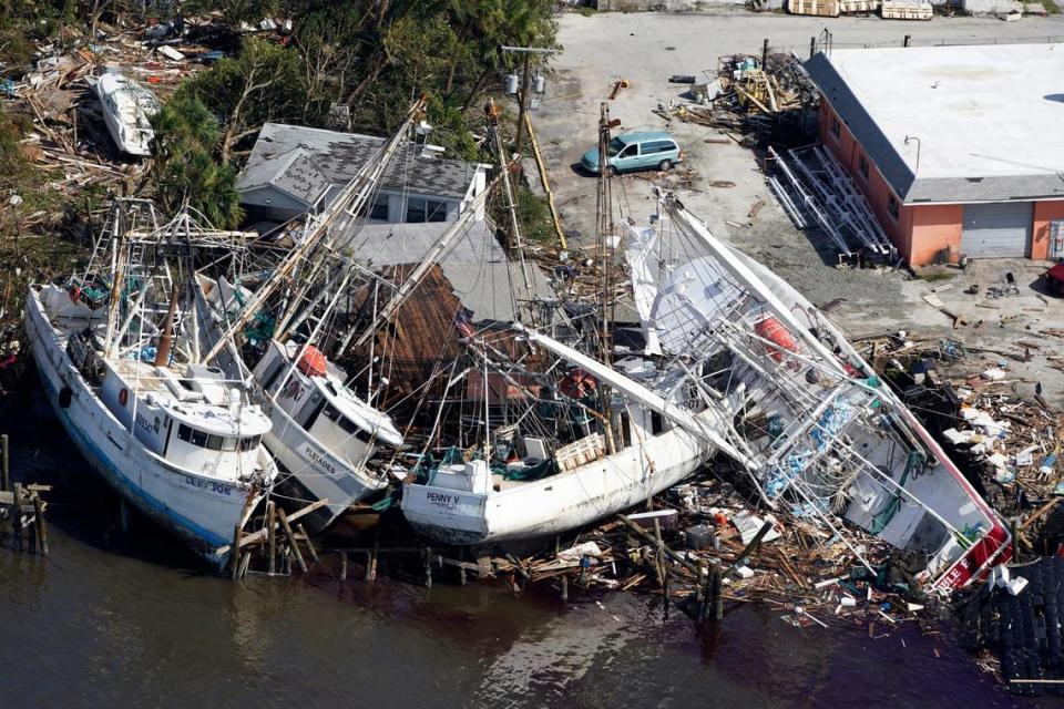 An aerial photo shows damaged boats and debris stacked along the shore in the aftermath of Hurricane Ian, Thursday, Sept. 29, 2022, in Fort Myers, Fla.