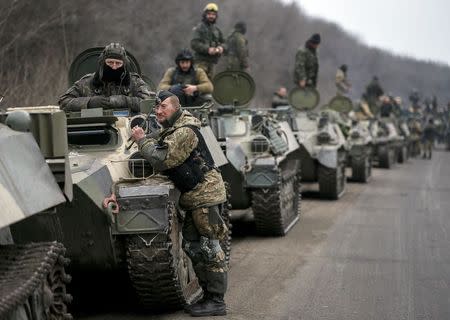 Members of the Ukrainian armed forces and armoured personnel carriers are seen preparing to move as they pull back from Debaltseve region, near Artemivsk February 26, 2015. REUTERS/Gleb Garanich