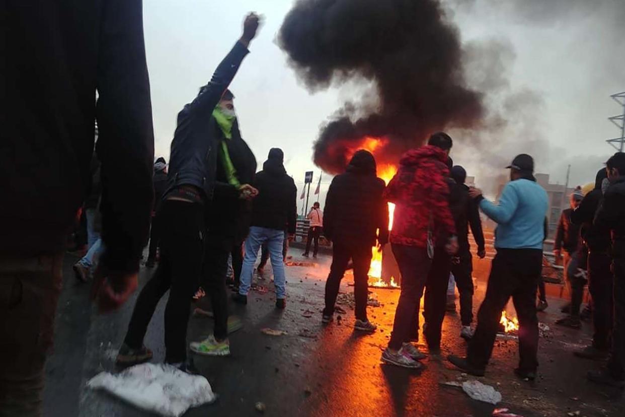 Iranian protesters gather around a fire during a demonstration against an increase in gasoline prices in the capital Tehran at the weekend: AFP via Getty Images