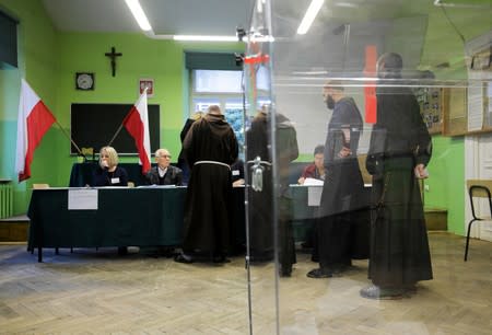 Monks line up to receive their ballots during parliamentary election at a polling station in Krakow