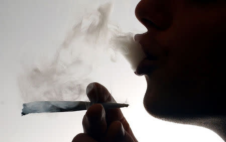 FILE PHOTO: An unidentified man smokes a cannabis cigarette at a house in London, Britain January 24, 2004. REUTERS/David Bebber/File Photo