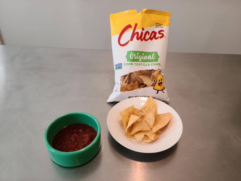 bag of chicas original tortilla chips and chips on a plate and a bowl of slasa