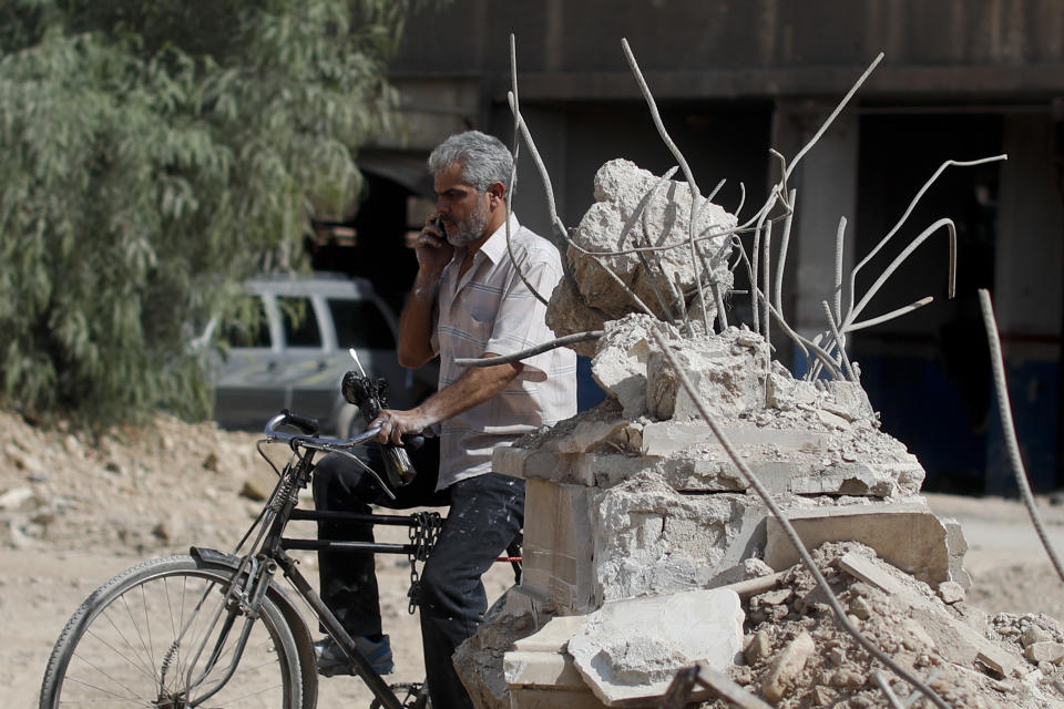 A man rides his bicycle at the Palestinian refugee camp of Yarmouk in the Syrian capital Damascus, Syria, Saturday, Oct. 6, 2018. Bulldozers and trucks are working to clear tons of rubble from the main streets. The camp, once home to the largest concentration of Palestinians outside the territories housing nearly 160,000 people, has been gutted by years of war. (AP Photo/Hassan Ammar)