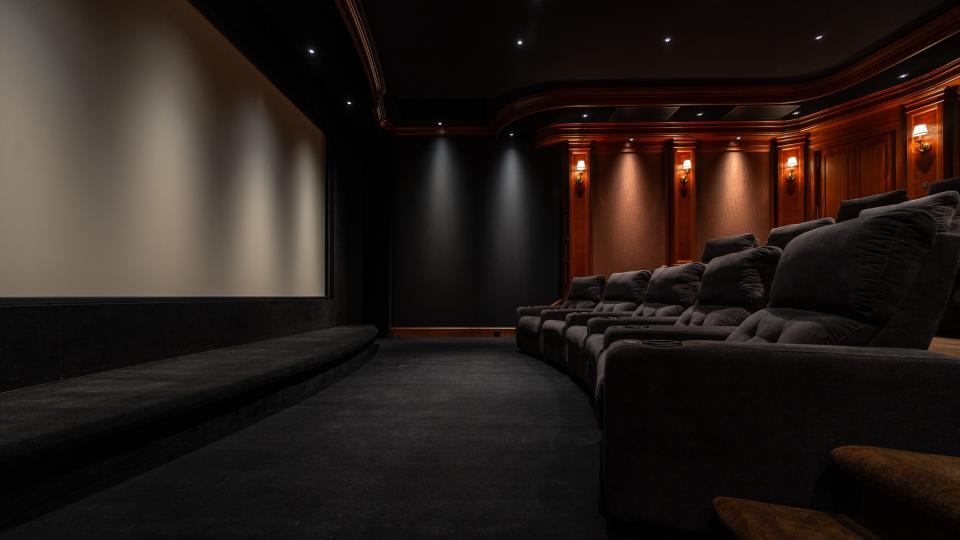 Home theater Hahn theater showing seating, lighting sconces and screen