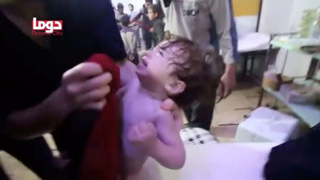 A child cries as they have their face wiped following alleged chemical weapons attack, in what is said to be Douma, Syria in this still image from video obtained by Reuters on April 8, 2018. White Helmets/Reuters TV via REUTERS