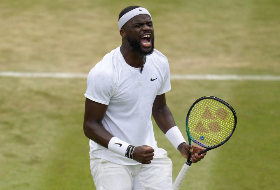 Frances Tiafoe of the US celebrates winning the second set against Kazakhstan's Alexander Bublik during their men's third round singles match on day five of the Wimbledon tennis championships in London, Friday, July 1, 2022. (AP Photo/Kirsty Wigglesworth)