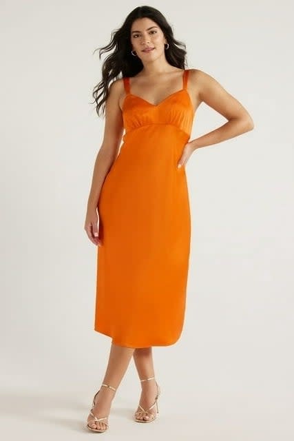 model in a sleek, sleeveless midi dress with thin straps and square neckline, paired with heeled sandals