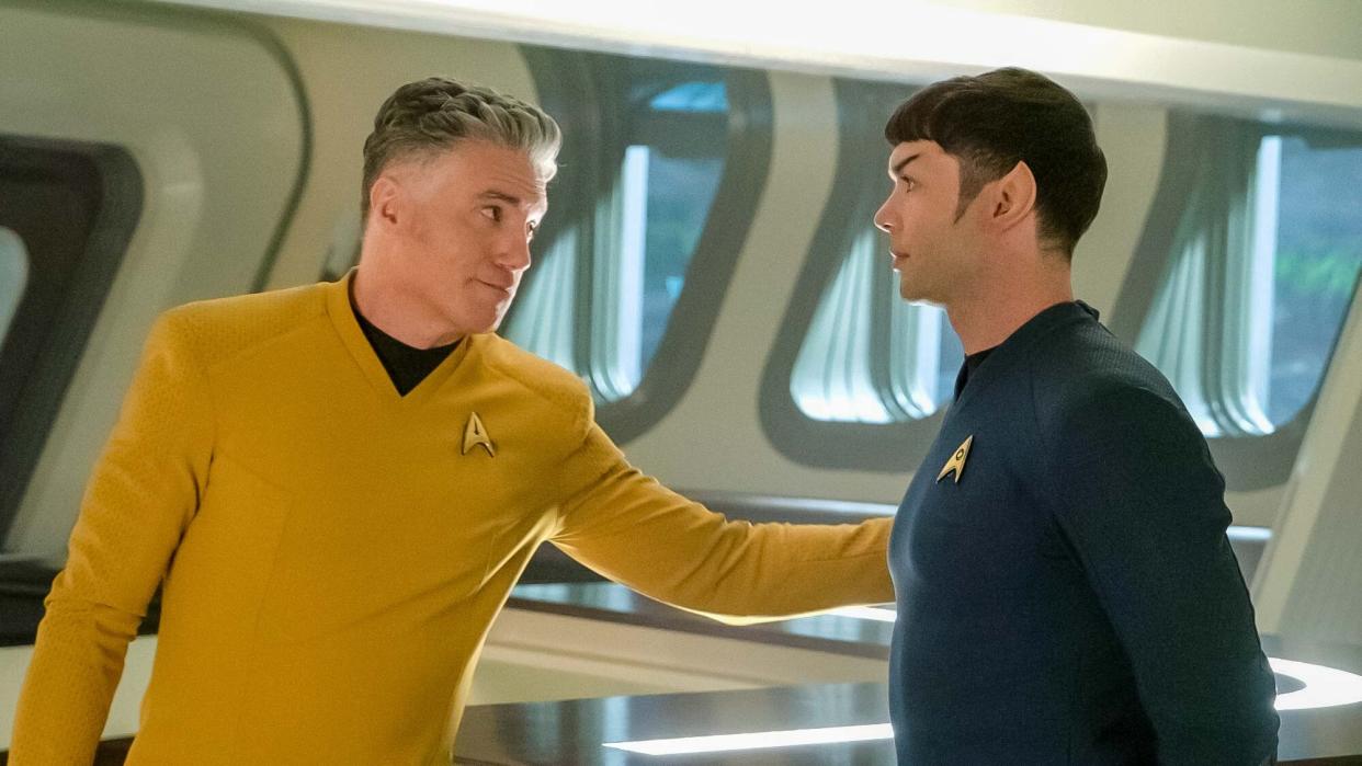  (L to R) Anson Mount as Pike, extends and arm to Ethan Peck as Spock in Star Trek: Strange New Worlds 