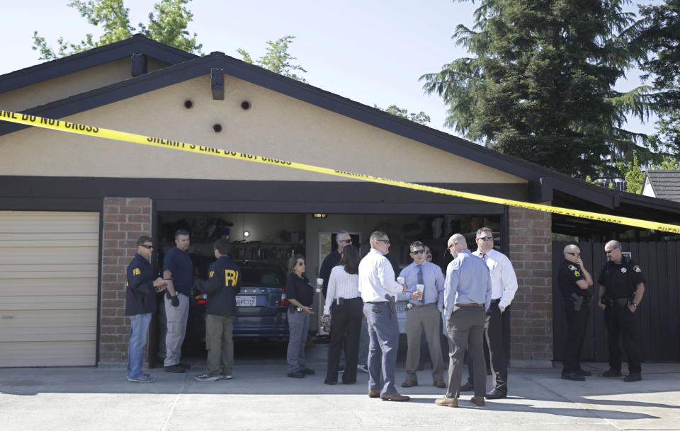 FILE - In this April 25, 2018 file photo, authorities gather outside the home of Joseph James DeAngelo in Citrus Heights, Calif. The home of DeAngelo, suspected of being the notorious "Golden State Killer", has been sold to a couple who intend to live there. The Sacramento Bee reports DeAngelo's 1,500-square-foot home in Citrus Heights, Calif., was sold last month. (AP Photo/Rich Pedroncelli,File)
