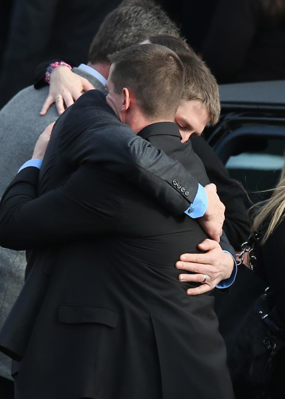 NEWTOWN, CT - DECEMBER 18: Family and friends embrace after the funeral for shooting victim Jessica Rekos, 6, at the St. Rose of Lima Catholic church on December 18, 2012 in Newtown, Connecticut. Funeral services were held at the church for both Jessica Rekos and James Mattioli, 6, Tuesday, four days after 20 children and six adults were killed at Sandy Hook Elementary School. (Photo by John Moore/Getty Images)