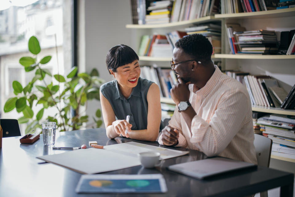 Two professionals engaging in a discussion with work materials on the table