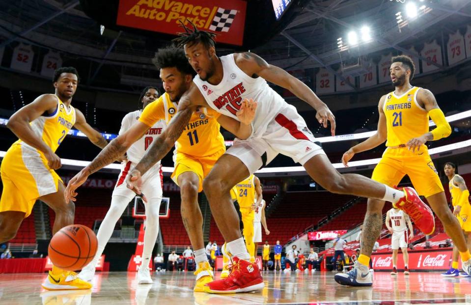 Pittsburgh’s Justin Champagnie (11) and N.C. State’s Manny Bates (15) go after the loose ball during N.C. State’s 65-62 victory over Pittsburgh at PNC Arena in Raleigh, N.C., Sunday, February 28, 2021.