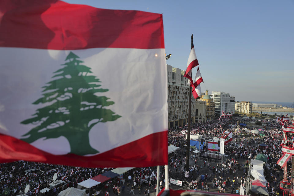 Anti-government protesters gather during separate civil parade at the Martyr square, in downtown Beirut, Lebanon, Friday, Nov. 22, 2019. Protesters gathered for their own alternative independence celebrations, converging by early afternoon on Martyrs' square in central Beirut, which used to be the traditional location for the official parade. Protesters have occupied the area, closing it off to traffic since mid-October. (AP Photo/Hassan Ammar)