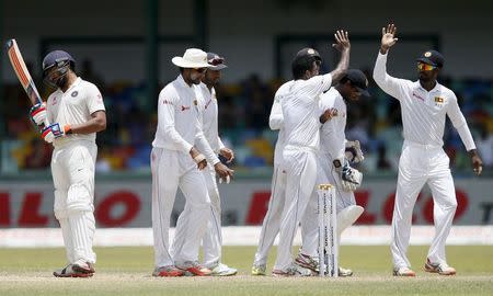 Sri Lanka's Dhammika Prasad (3rd R) celebrates with teammates after taking the wicket of India's Rohit Sharma (L) during the fourth day of their third and final test cricket match in Colombo August 31, 2015. REUTERS/Dinuka Liyanawatte