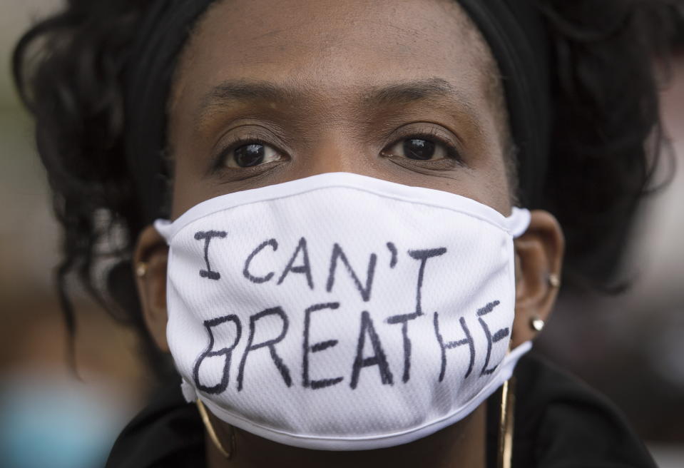 A woman attends a demonstration calling for justice for George Floyd in Montreal. Floyd died after he was pinned at the neck by a Minneapolis police officer. Source: AP