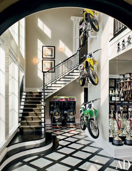 The staircase at motocross racer Ricky Carmichael's <a rel="nofollow noopener" href="https://www.architecturaldigest.com/story/ricky-carmichael-home-article?mbid=synd_yahoo_rss" target="_blank" data-ylk="slk:Tallahassee, Florida home;elm:context_link;itc:0;sec:content-canvas" class="link ">Tallahassee, Florida home</a> is painted in black and white to match the graphic floor.