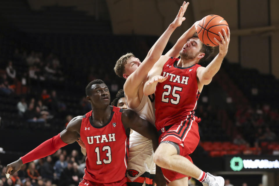 Utah guard Rollie Worster (25) is fouled by Oregon State forward Tyler Bilodeau as Utah center Keba Keita (13) watches during the second half of an NCAA college basketball game in Corvallis, Ore., Thursday, Jan. 26, 2023. Utah won 63-44. (AP Photo/Amanda Loman)