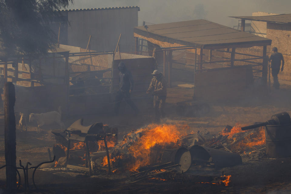 Workers try to extinguish smoldering embers on a ranch during the Easy Fire in Simi Valley, Calif. on Oct. 30, 2019. (Photo: Patrick T. Fallon/Bloomberg via Getty Images