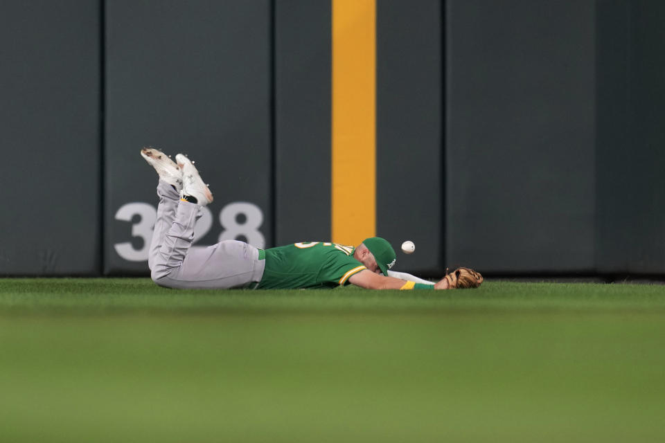 Oakland Athletics left fielder Seth Brown lies on the ground after trying to catch an RBI double by Minnesota Twins' Kyle Farmer during the second inning of a baseball game Wednesday, Sept. 27, 2023, in Minneapolis. (AP Photo/Abbie Parr)