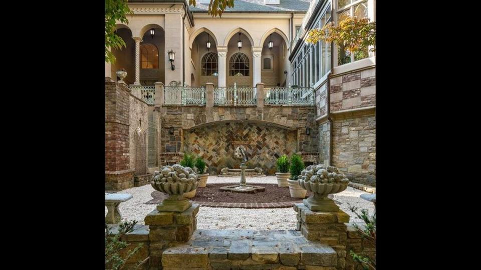 The courtyard below the two-level terrace of the mansion has a lion fountain and views of greenery.