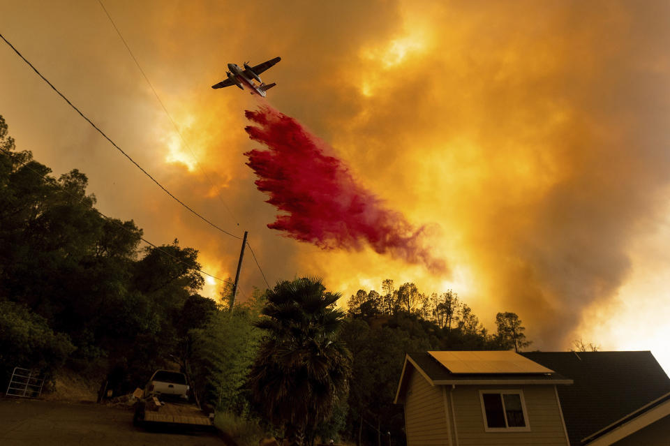 FILE - In this Aug. 18, 2020, file photo, an air tanker drops retardant as the LNU Lightning Complex fires tear through the Spanish Flat community in unincorporated Napa County, Calif. Two unusual weather phenomena combined to create some of the most destructive wildfires the West Coast states have seen in modern times. (AP Photo/Noah Berger, File)