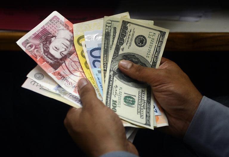 An Indian money changer counts foreign currency notes in New Delhi on August 27, 2013