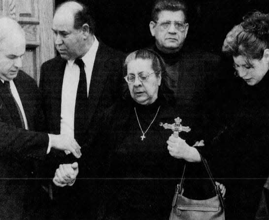 Andrea Adams, center, carries a crucifix as she is led on Wednesday, Feb. 20, 2002, from St. George Greek Orthodox Church in Piscataway after the funeral service for her brother, Costas Christofi, who was found shot to death at Jayson Williams’ Alexandria estate.