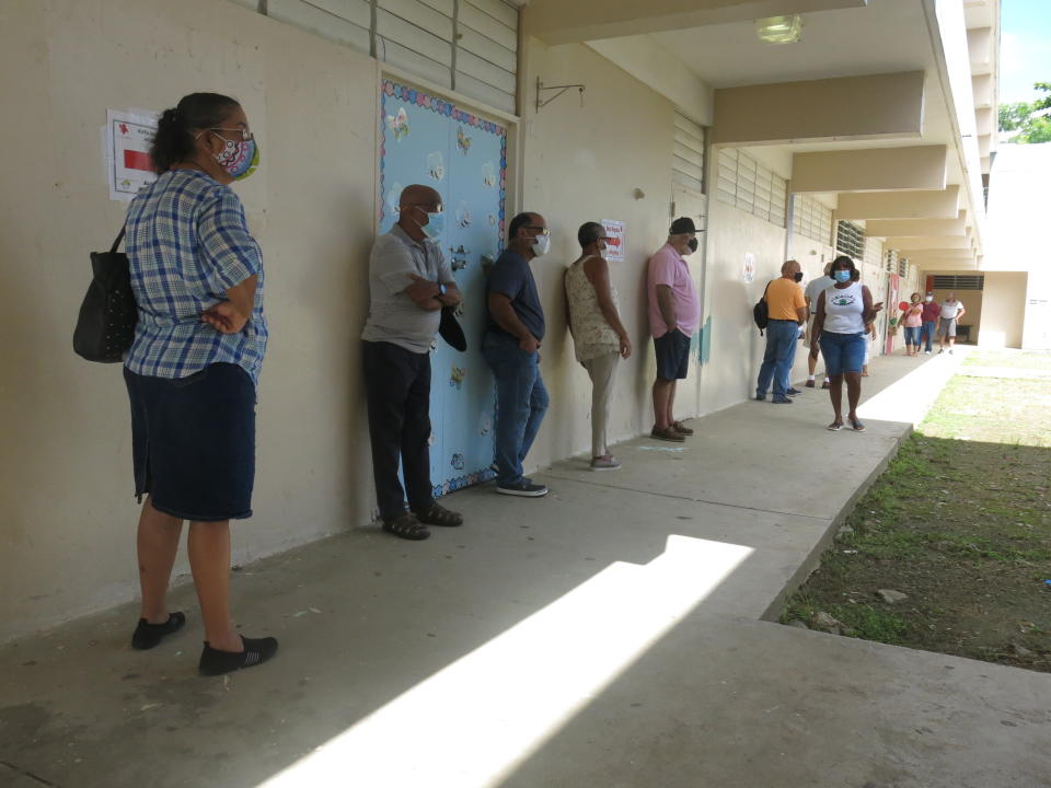 Voters wait to cast their ballots in Loíza, Puerto Rico, Sunday, Aug. 16, 2020. Thousands of Puerto Ricans on Sunday got a second chance to vote for the first time, a week after delayed and missing ballots marred the original primaries in a blow to the U.S. territory’s democracy. (AP Photo/Dánica Coto)