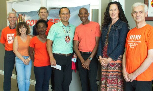 Ted Jaleta, third from right, and the Jaleta Pacers Running Club presented the donation to Cowessess First Nation Chief Cadmus Delorme, fourth from right, on Wednesday. (Submitted by the Jaleta Pacers Running Club - image credit)