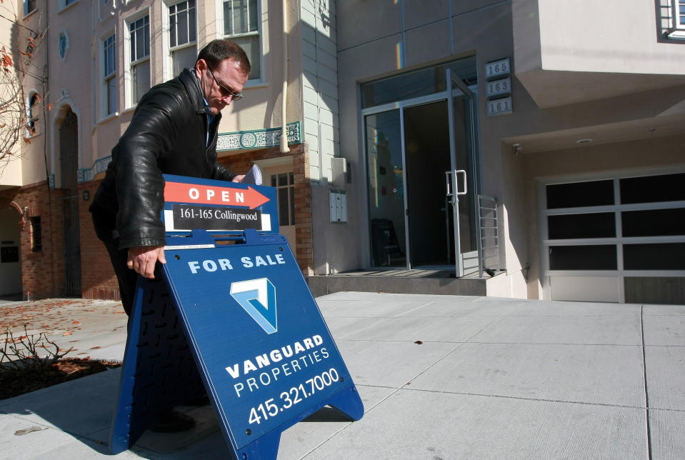 Real estate agent Brad Smith posts a for sale sign outside of an open house in San Francisco, California.  (Photo by Justin Sullivan/Getty Images)