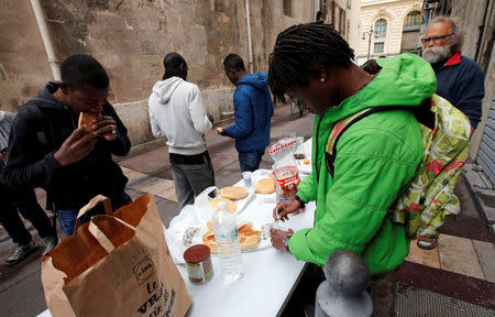 FILE PHOTO: Volunteers distribute foods to migrants as they occupy the Saint Ferreol church to protest against the life conditions of unaccompanied minor migrants in Marseille, France, November 22, 2017. Picture taken November 22, 2017. REUTERS/Jean-Paul Pelissier/File Photo