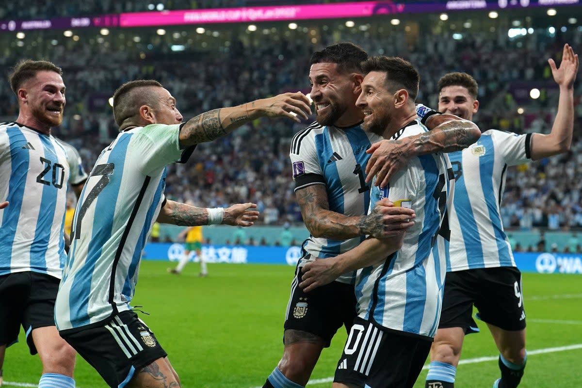 Lionel Messi, second right, is mobbed by his team-mates after scoring Argentina’s opening goal against Australia (Martin Rickett/PA) (PA Wire)