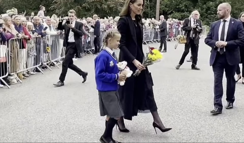 A screenshot of Princess Kate and Elizabeth Sulkovska laying a toy corgi and flowers among the tributes left to the Queen (PA)