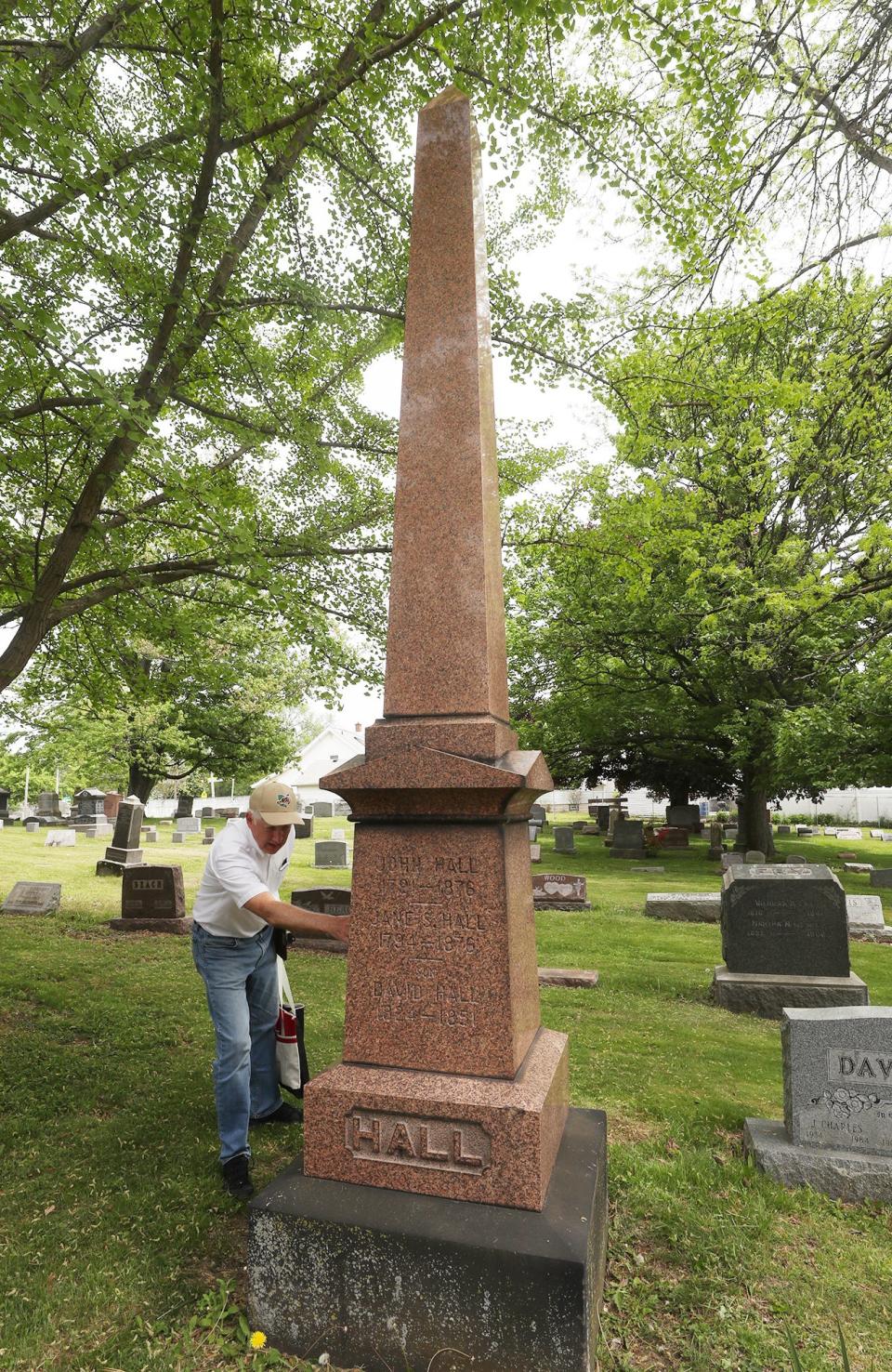 Jim Weyrick checks the names on the Hall family obelisk at Ellet Cemetery in Akron. The pink granite memorial is the tallest monument in the 3-acre cemetery.