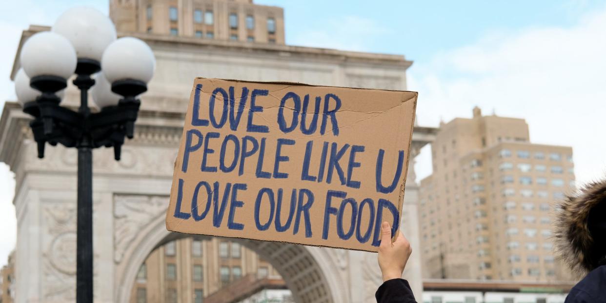 A woman holds a sign that reads "love our people like u love our food" at the End The Violence Towards Asians rally in Washington Square Park on February 20, 2021 in New York City. Since the start of the coronavirus pandemic, violence towards Asian Americans has increased at a much higher rate than previous years. The New York City Police Department (NYPD) reported a 1,900% increase in anti-Asian hate crimes in 2020.