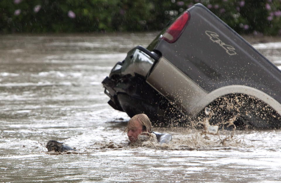 Kevan Yaets swims after his cat Momo to safety as the flood waters sweep him downstream and submerge the cab in High River, Alberta on June 20, 2013 after the Highwood River overflowed its banks. Hundreds of people have been evacuated with volunteers and emergency crews helping to aid stranded residents.