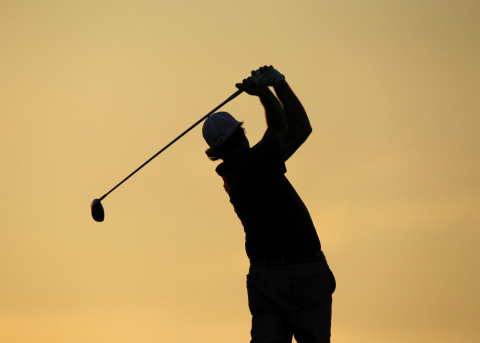 Phil Mickelson of the U.S. is silhouetted during sunset as he hits from the 11th tee during the first round of the 92nd PGA Golf Championship at Whistling Straits in Kohler, Wisconsin August 12, 2010. REUTERS/Matt Sullivan (UNITED STATES - Tags: SPORT GOLF)
