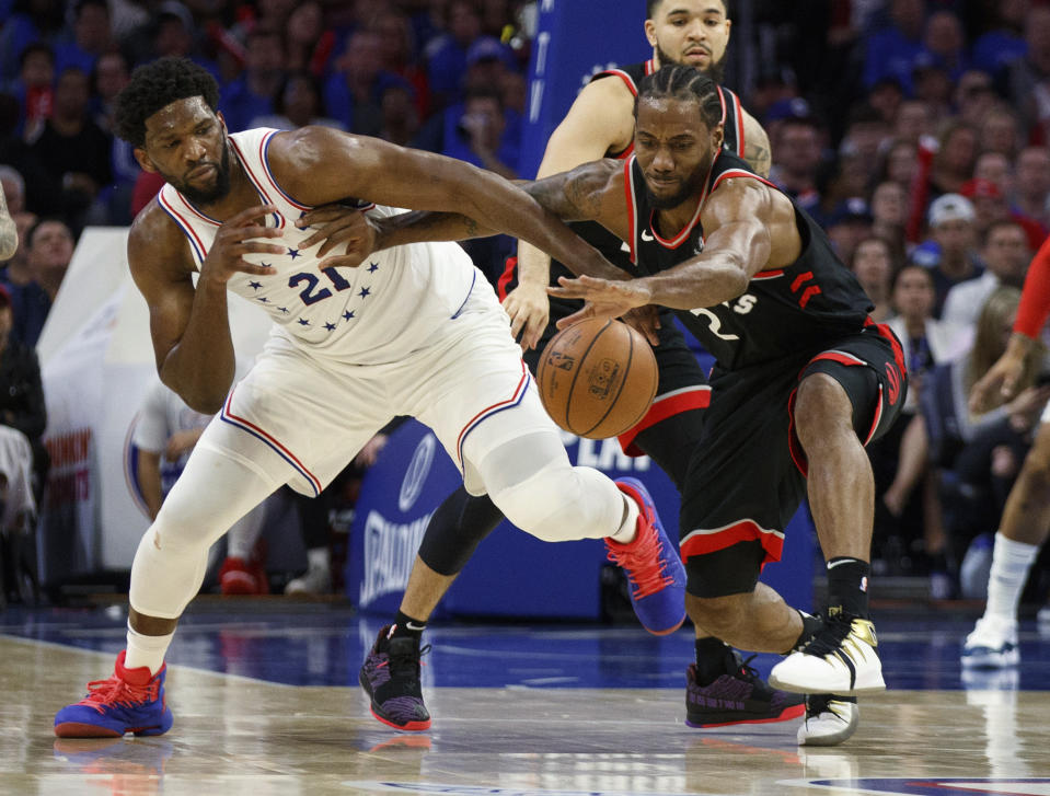 Toronto Raptors' Kawhi Leonard, right, reaches for the ball as he holds off Philadelphia 76ers' Joel Embiid, left, during the second half of Game 3 of a second-round NBA basketball playoff series Thursday, May 2, 2019, in Philadelphia. The 76ers won 116-95. (AP Photo/Chris Szagola)
