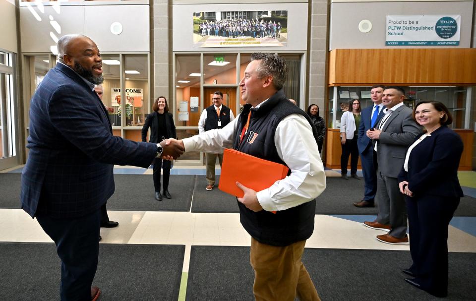 Uxbridge High School Principal Michael Rubin, right, welcomes state Secretary of Education Patrick Tutwiler upon his arrival at the school Friday to learn more about the district’s Innovation Pathways program.