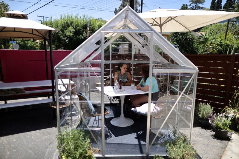 People eat lunch in a social distancing greenhouse dining pod amid the outbreak of the coronavirus disease (COVID-19) in Los Angeles
