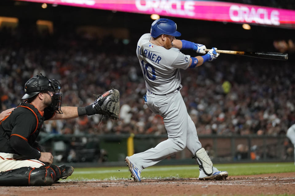 Los Angeles Dodgers designated hitter Justin Turner, right, hits an RBI single in front of San Francisco Giants catcher Joey Bart during the fourth inning of a baseball game in San Francisco, Saturday, Sept. 17, 2022. (AP Photo/Jeff Chiu)