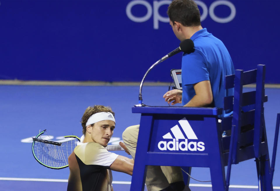 In this photo released by MexTenis, third-ranked Alexander Zverev of Germany smashes his racket on the umpire's chair moments after losing a doubles match of the Mexican Open tennis tournament in Acapulco, Mexico, Tuesday, Feb. 22, 2022. Zverev was thrown out of the Mexican Open after he struck the umpire's chair three times, sat for a moment, then got back up and yelled at umpire Alessandro Germani that he "destroyed the whole (expletive) match" and struck the chair once more with his racket as the umpire climbed down. (Marcos Dominguez/MexTenis via AP)